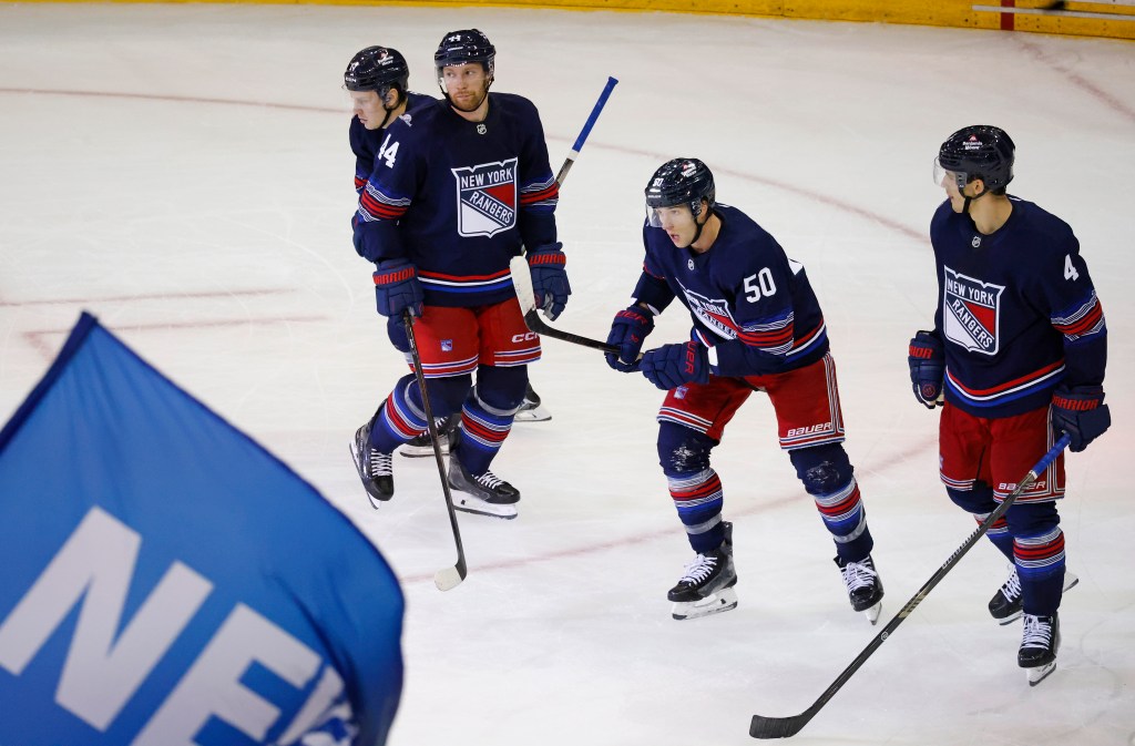 New York Rangers left wing Will Cuylle celebrates a goal with his teammates on the ice.