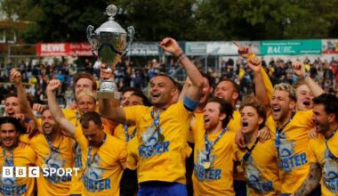 Lokomotive Leipzig players celebrate and hold up their trophy