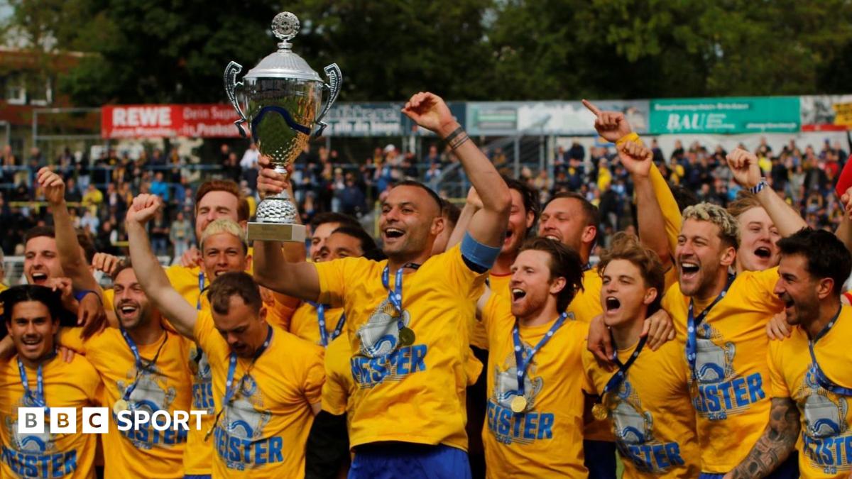 Lokomotive Leipzig players celebrate and hold up their trophy