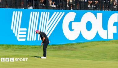 Jon Rahm playing a shot in front of a large banner saying LIV Golf