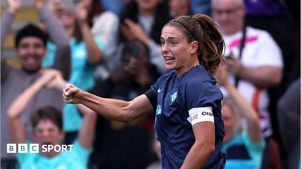 Alexia Putellas celebrating a goal with a clenched right fist as fans show their excitement in the background, raising their arms and applauding