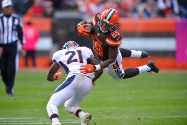 Cleveland Browns running back Duke Johnson (29) is tackled by Denver Broncos cornerback Aqib Talib (21) during an NFL football game Sunday Oct. 18, 2015, in Cleveland. Denver won 26-23 in overtime. (AP Photo/David Richard)