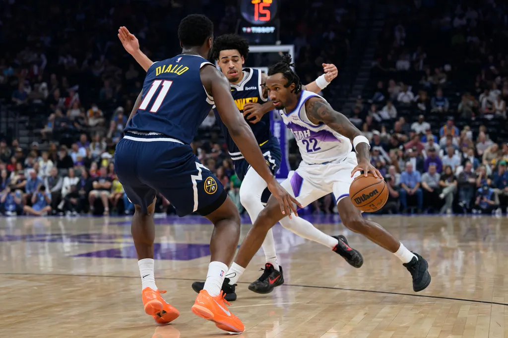 Utah Jazz guard Darryn Peterson (22) looks to drive to the basket during defended by Denver Nuggets forward Alpha Diallo (11) the first half of an NBA basketball game, Tuesday, Oct. 6, 2026, in Salt Lake City. (AP Photo/Tyler Tate)