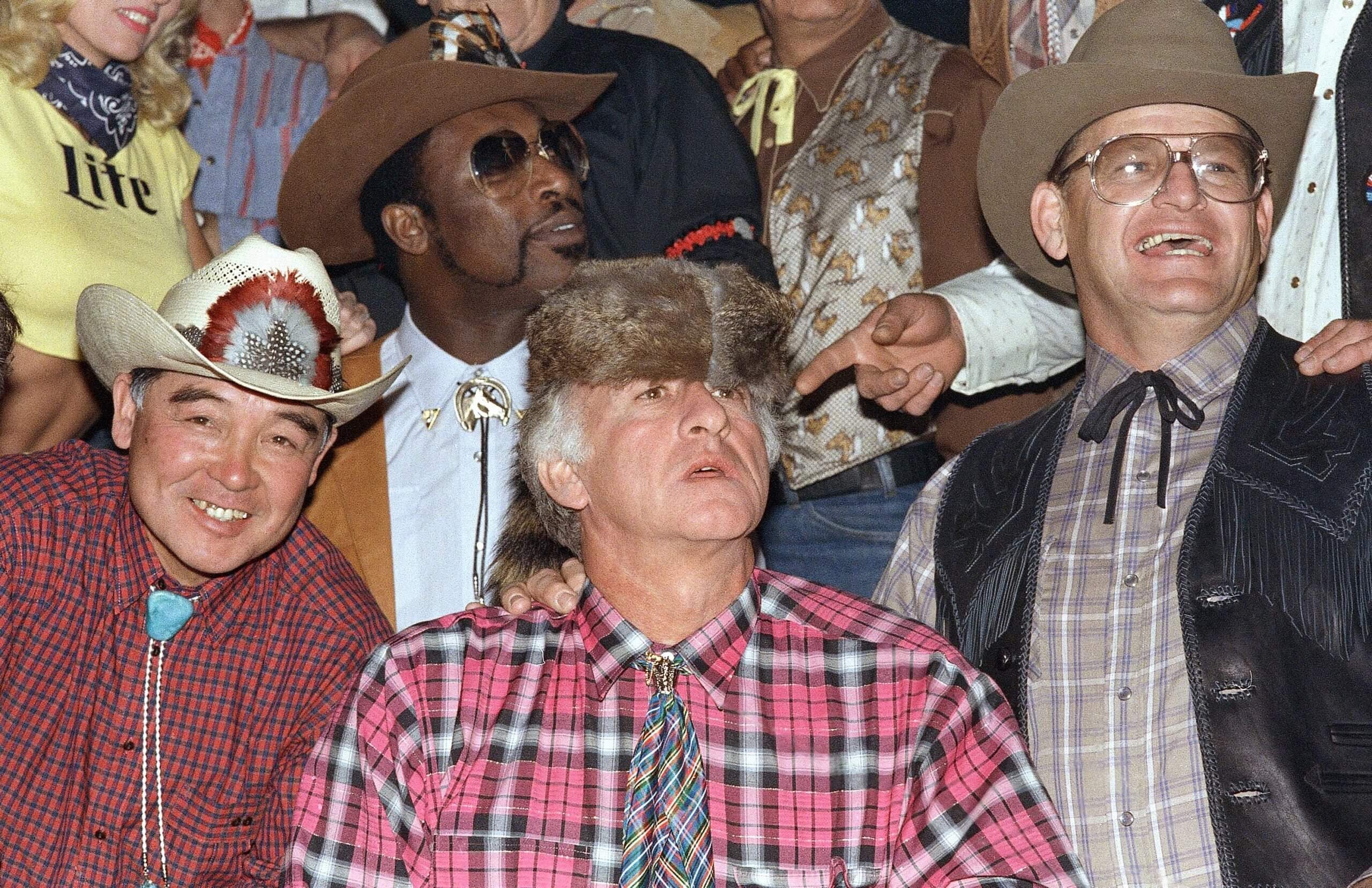 Bob Uecker, dons a Daniel Boone hat during group picture before taping of the 11th annual Miller Lite commercial, in 1987.