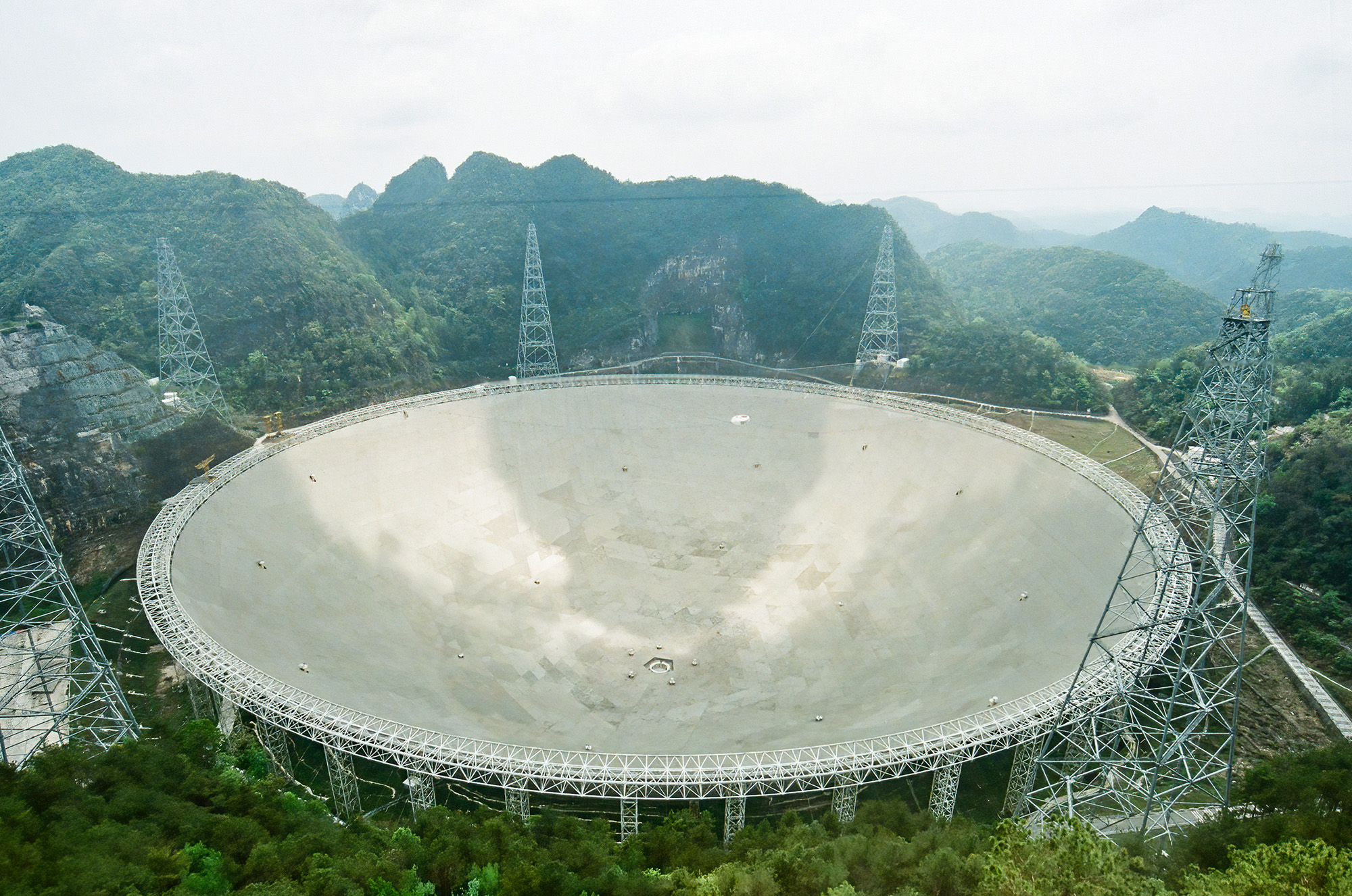 A large circular disk is seen in the middle of a forrested region.