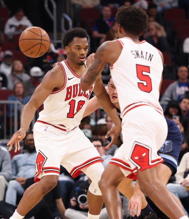 Bulls center Tobe Awaka (19) passes to guard Dailyn Swain (5) as Grizzlies center Quinten Post defends in the fourth quarter of a preseason game at the United Center on Oct. 9, 2026, in Chicago. (John J. Kim/Chicago Tribune)