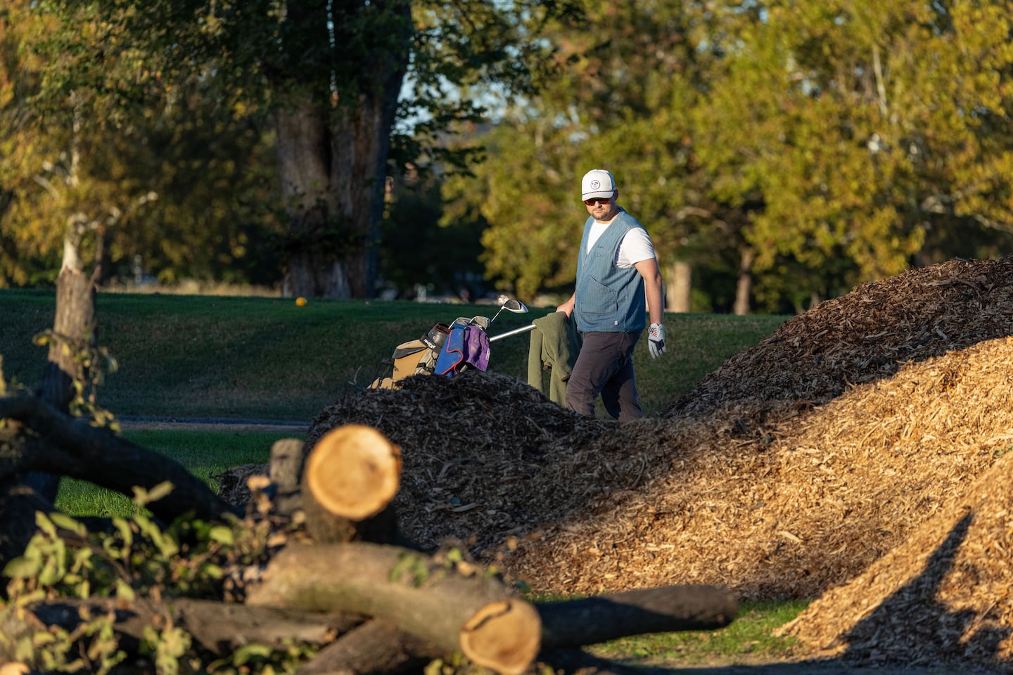 Golfers walked by piles of logs and debris on the course at East Potomac Golf Links on Oct. 18. 