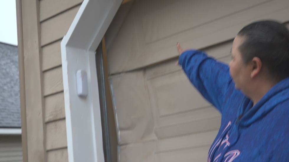 Andreea Koski shows where a brown bear tried to break into the garage