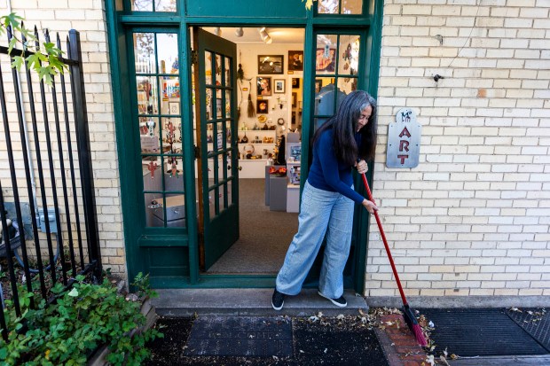 Member artist Marian Hesse sweeps leafs from the back door during her shift at Madison and Main Gallery in Greeley on Friday, Oct. 16, 2026. (Brice Tucker/Staff Photographer)