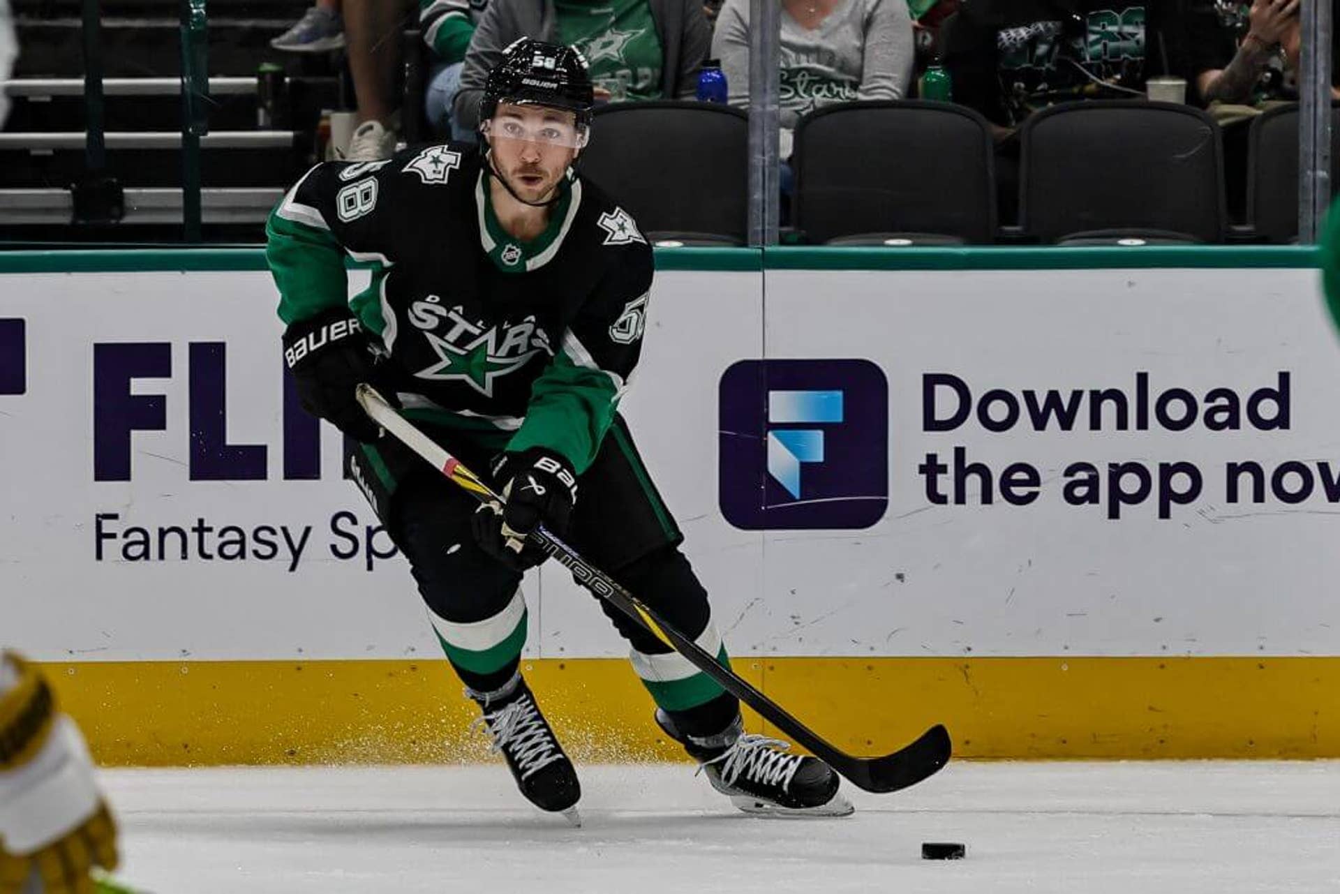 Wearing a black and green Dallas Stars jersey, Michael Bunting skates with the puck during a game in the 2025-26 season.
