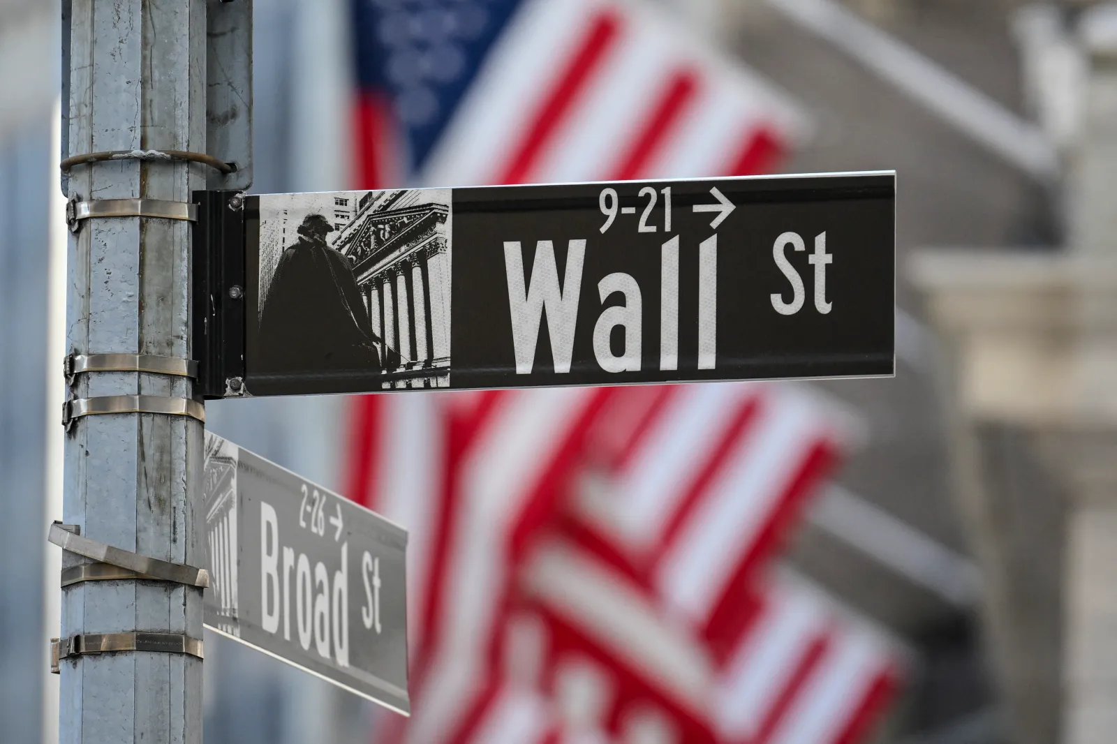 An American flag behind a Wall Street sign near the New York Stock Exchange in New York City on October 19, 2026.