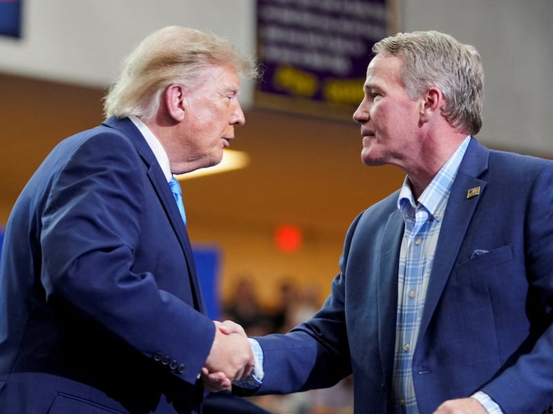 Senator Jon Husted shakes hands with US President Donald Trump at a rally at Butler High School in Vandalia, Ohio, US, October 3, 2026.
