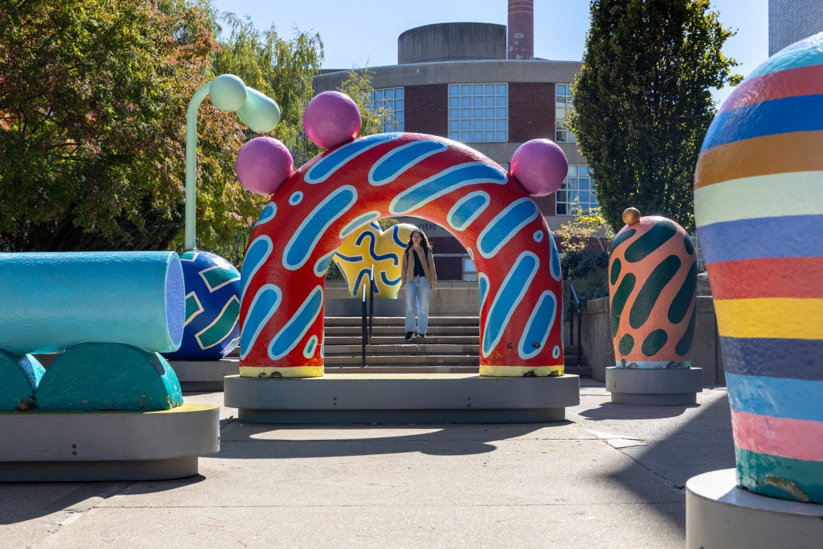 A student walks past colorful statues near Stearns Center Oct. 7. Northeastern enrolled over 7,000 Class of 2030 undergraduate students to all of its campuses this fall.