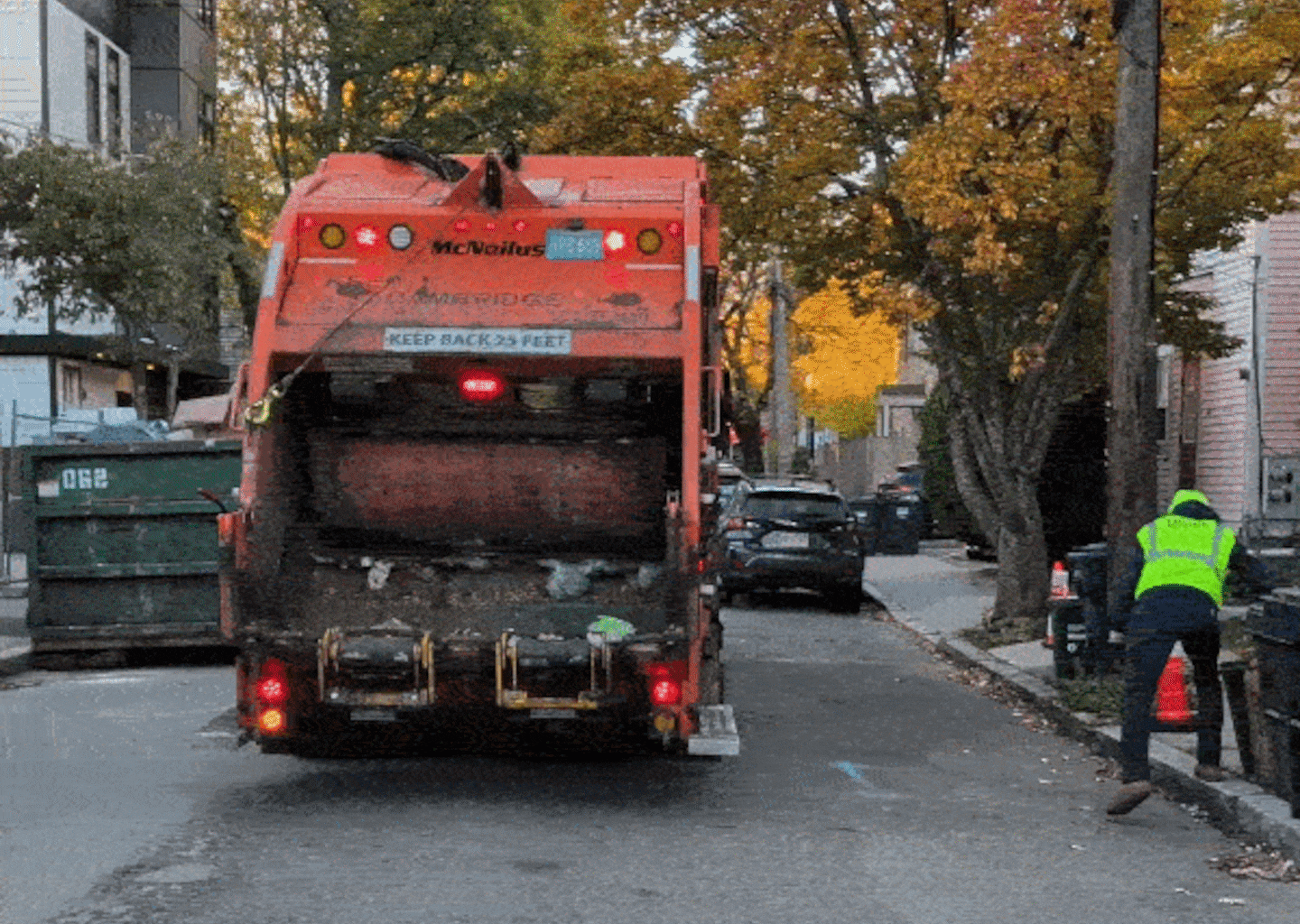 A worker hoisted a food waste bin into a truck in Cambridge.