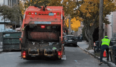 A worker hoisted a food waste bin into a truck in Cambridge.