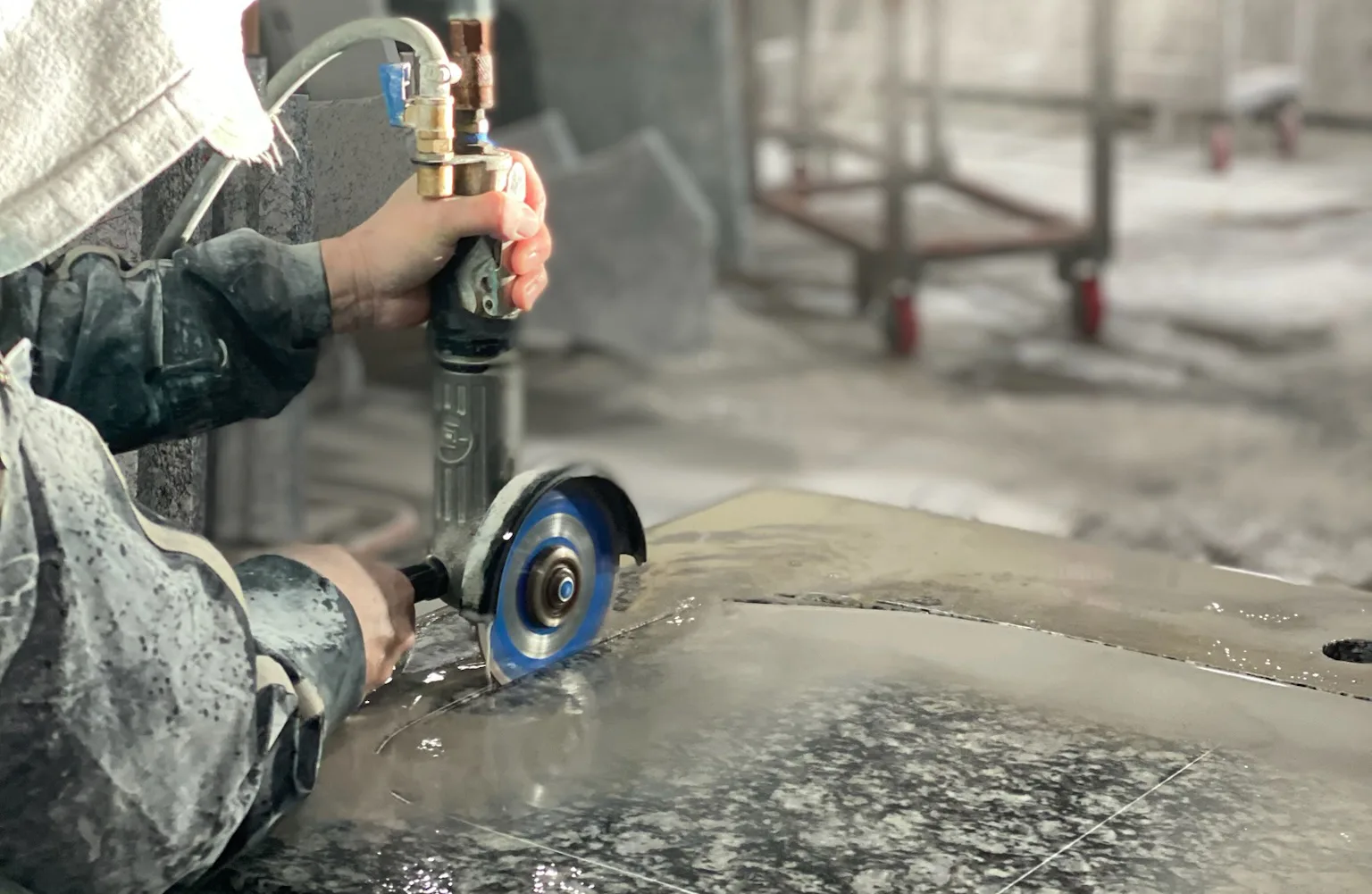 A person using a circular grinder to cut a hole in a countertop.