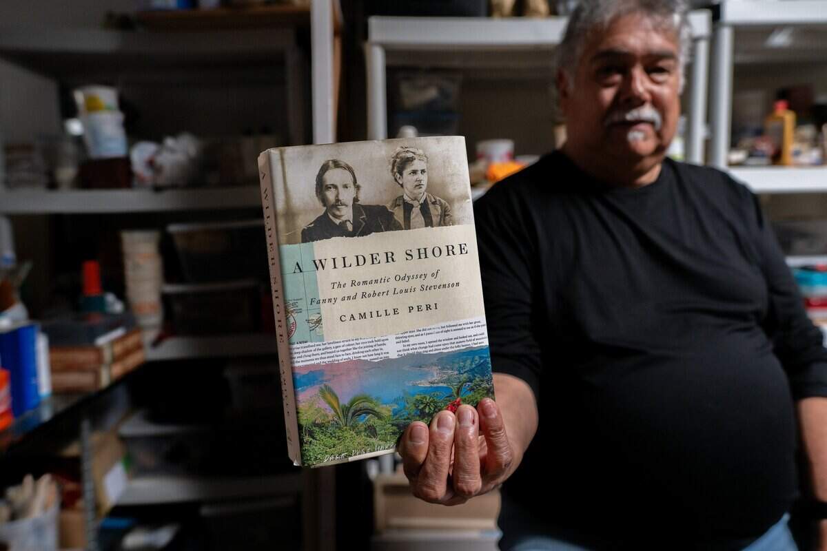 Sculptor Garr Ugalde holds a book by author Camille Peri in his studio in Sacramento on last month. Ugalde said the book changed the direction of his Robert Louis Stevenson Public Art Project to include Stevenson’s wife, Fanny Osbourne Stevenson.