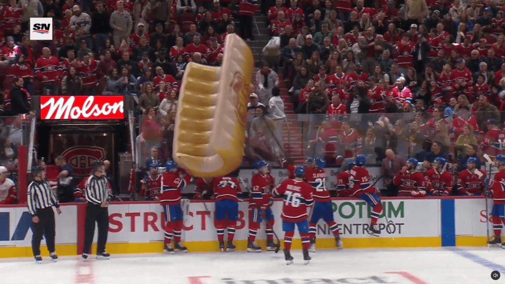 An inflatable hot dog bun hits the Canadiens' bench while falling onto the ice at Bell Centre on Saturday night.