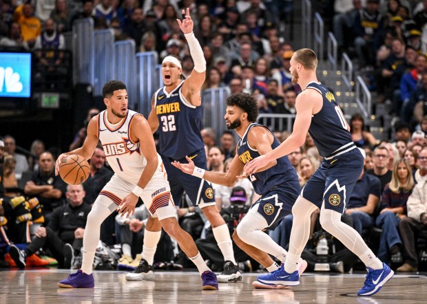 Devin Booker (1) of the Phoenix Suns works as Aaron Gordon (32), Jamal Murray (27) and Christian Braun (0) of the Denver Nuggets defend during the first quarter at Ball Arena on Saturday, Oct. 25, 2025. (Photo by AAron Ontiveroz/The Denver Post)
