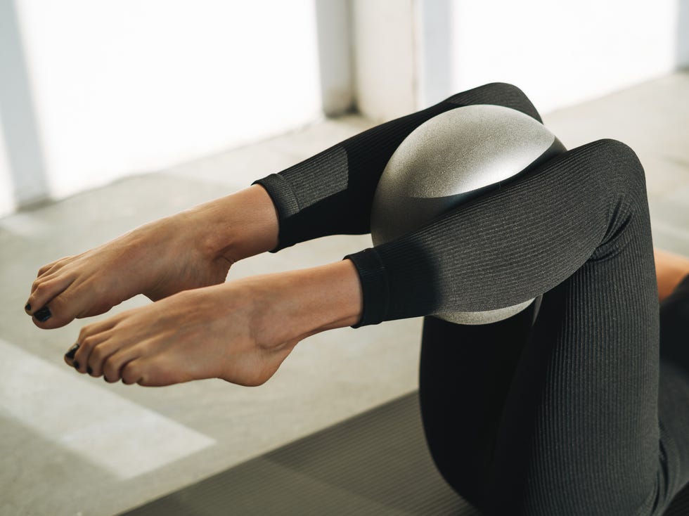 woman in sportswear doing Pilates stretching on mat with ball in modern studio woman in sportswear doing pilates stretching on mat with ball in modern studio