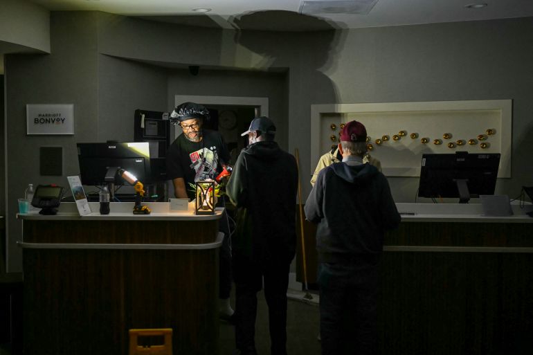 Hotel guests are assisted using flashlights as electricity went off shortly before Hurricane Isaias’ landfall in Pensacola, Florida, on October 9, 2026. [AFP]