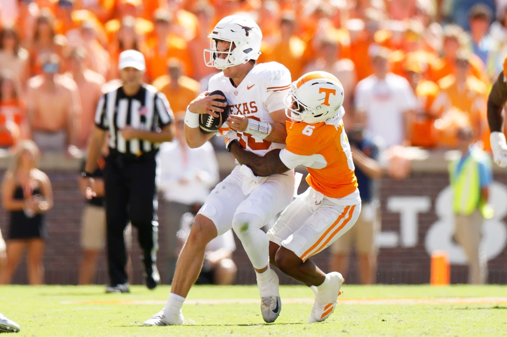 Arch Manning of the Texas Longhorns is tackled by Qua Moss of the Tennessee Volunteers.