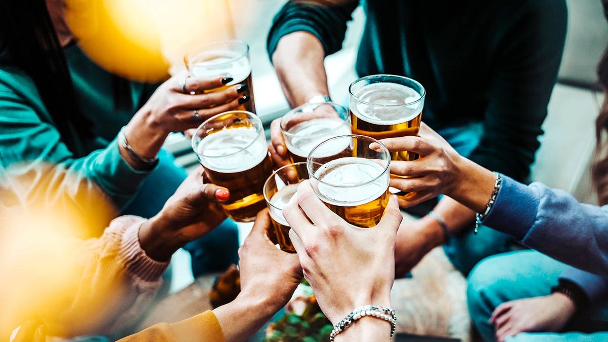 Group of people drinking beer at a brewery pub restaurant bar table.