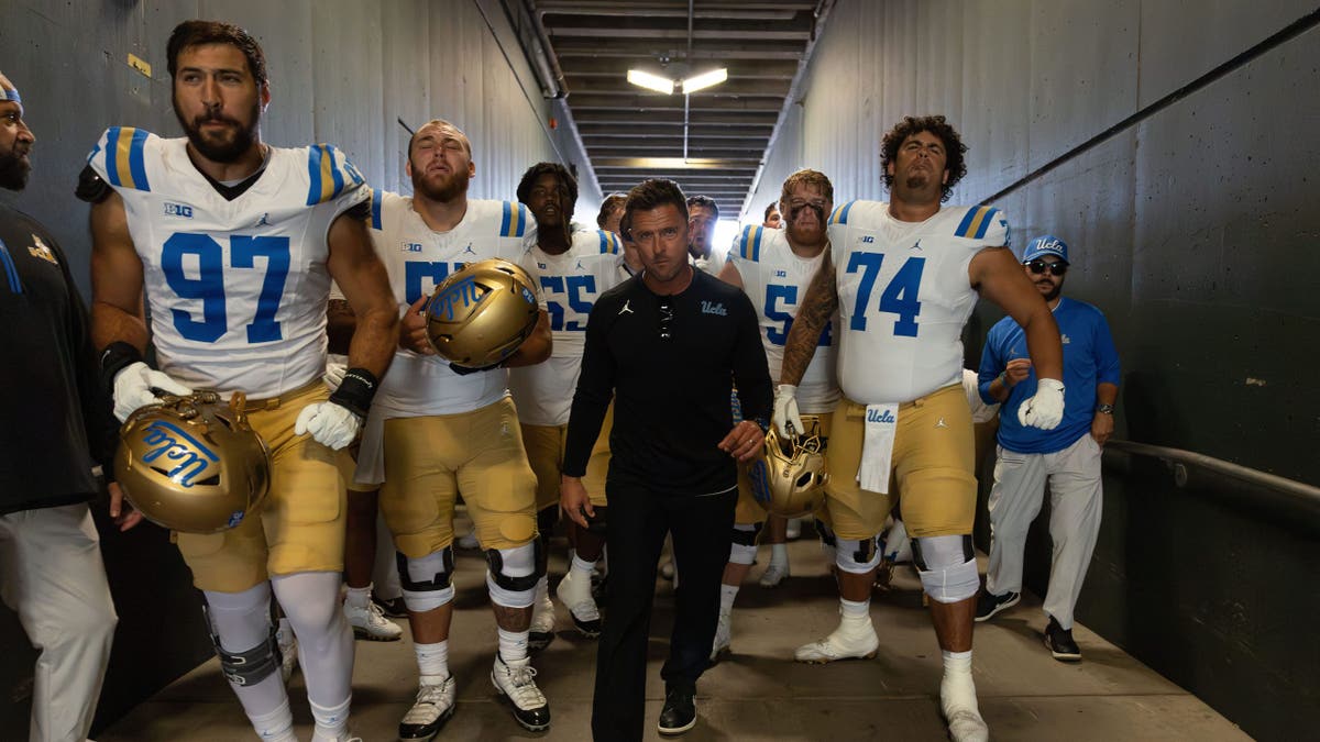 Bob Chesney leads the UCLA Bruins onto the field at Autzen Stadium in Eugene, Ore.