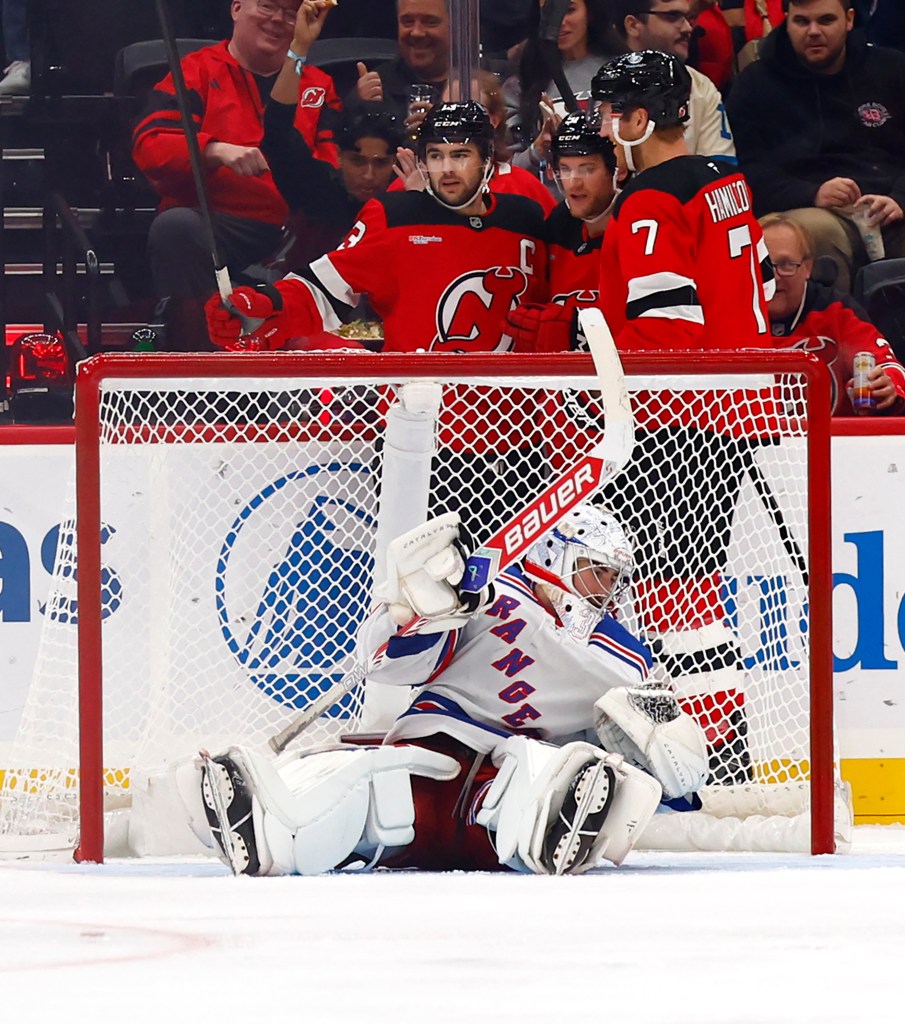 New Jersey Devils center Nico Hischier celebrates a goal against New York Rangers goaltender Dylan Garand.