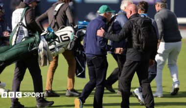 Dermot Desmond being escorted off the golf course by security