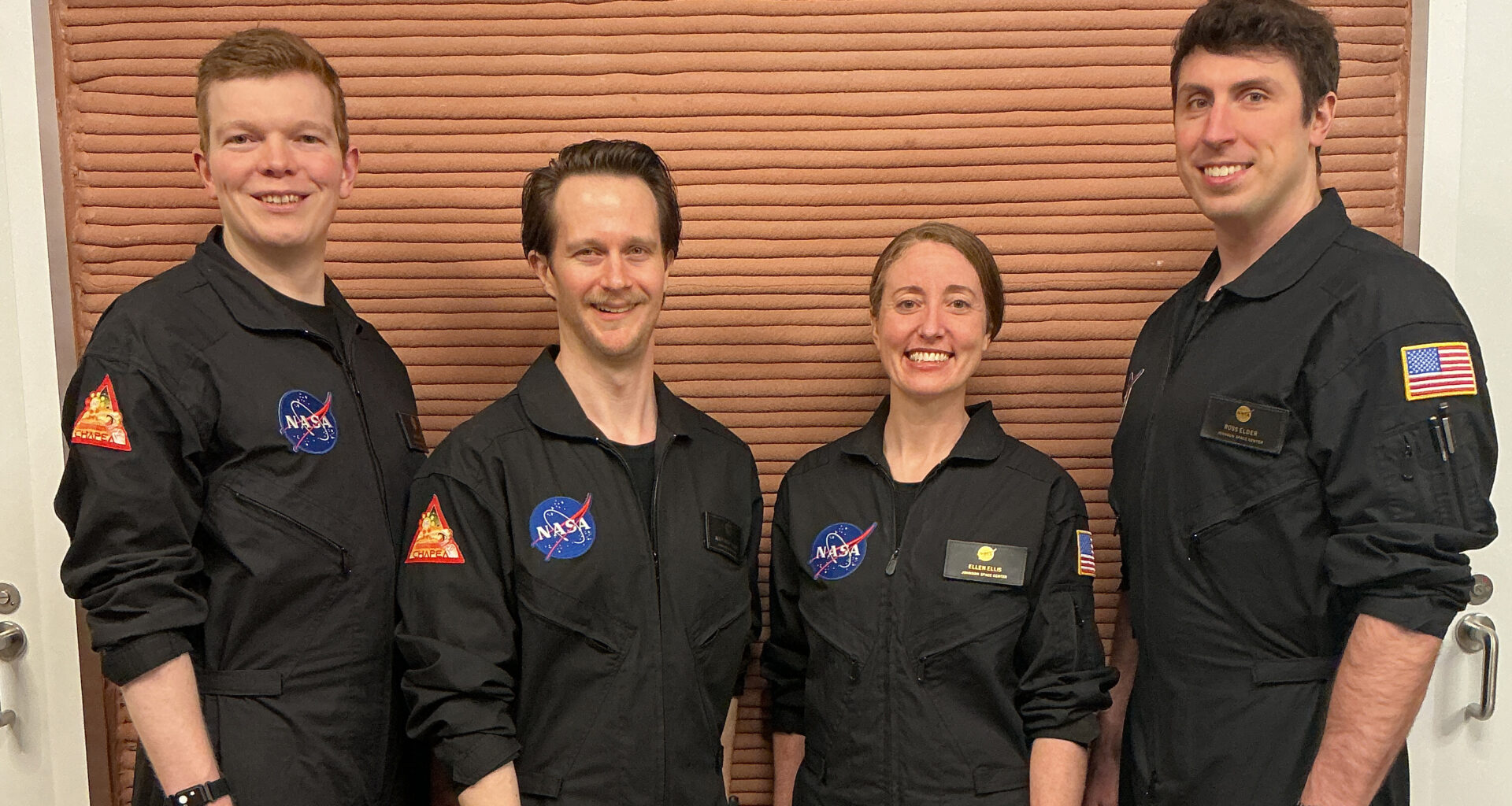 Members of NASA’s CHAPEA (Crew Health and Performance Exploration Analog) Mission 2 crew stands in their workspace after spending a year in their isolated and confined habitat at NASA’s Johnson Space Center in Houston. (from left: James Spicer, Matthew Montgomery, Ellen Ellis, and Ross Elder). Credit: NASA