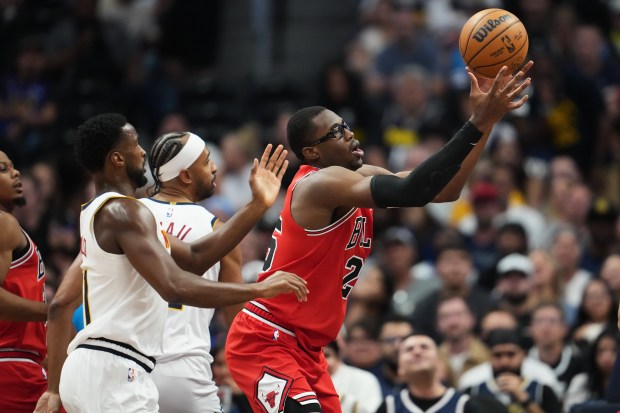 Chicago Bulls center Jalen Smith, right, pulls in a rebound as Denver Nuggets guard Alpha Diallo, front left, and forward Zeke Nnaji defend in the first half of a preseason NBA basketball game Sunday, Oct. 11, 2026, in Denver. (AP Photo/David Zalubowski)