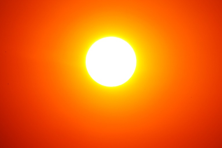 The Sun as a bright circle surrounded by orange sky.
