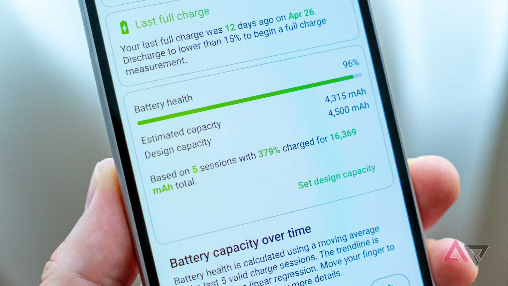 a phone in hand displaying battery health status in the accubattery app