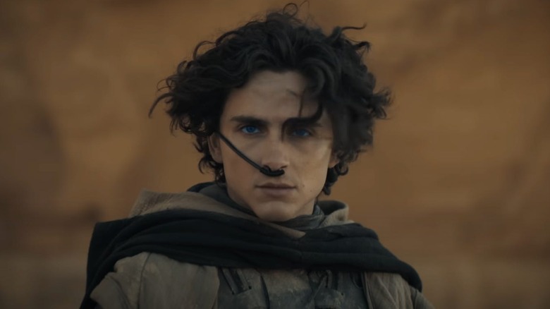 Timothée Chalamet as Paul Atreides in Dune: Part One, wearing a water retaining system while looking off.