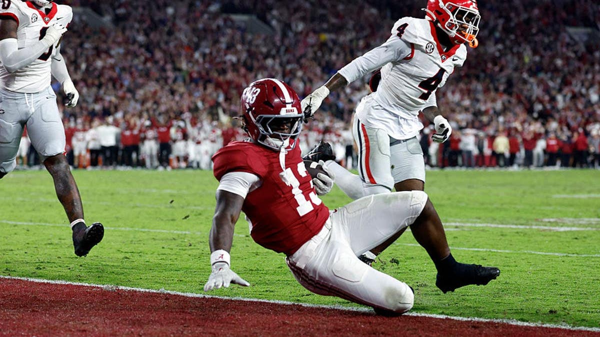 EJ Crowell runs past KJ Bolden for a touchdown during an Alabama-Georgia football game.