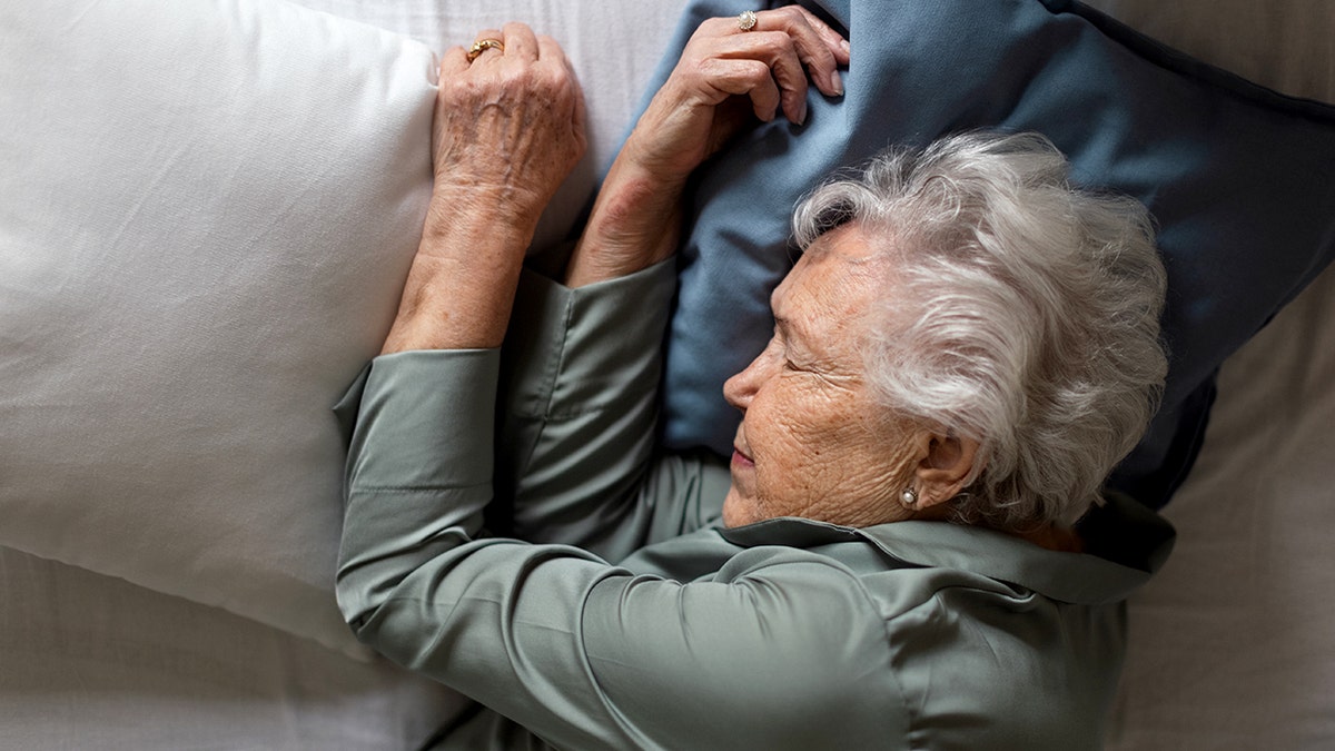 Senior woman sleeping in her bed, high angle view.
