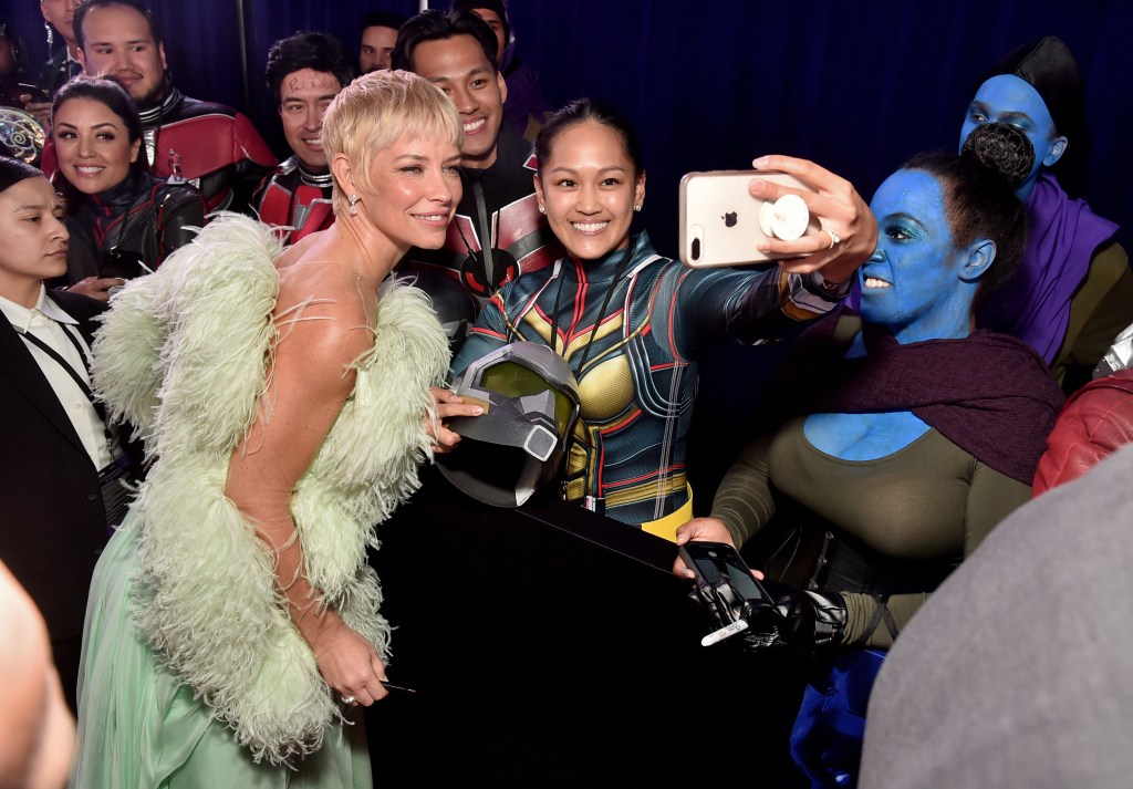 Evangeline Lilly poses with fans for a selfie at a movie premiere.