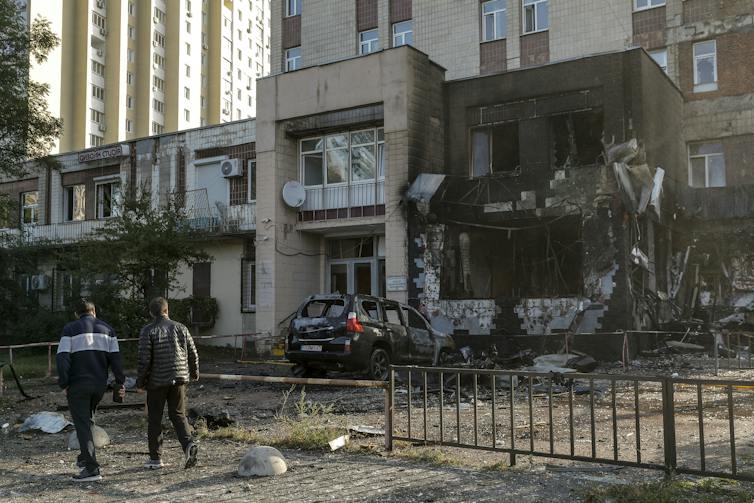 Local residents walk past the site of a Russian strike on a coffee shop in a residential area of Kyiv, Ukraine, 28 September 2026