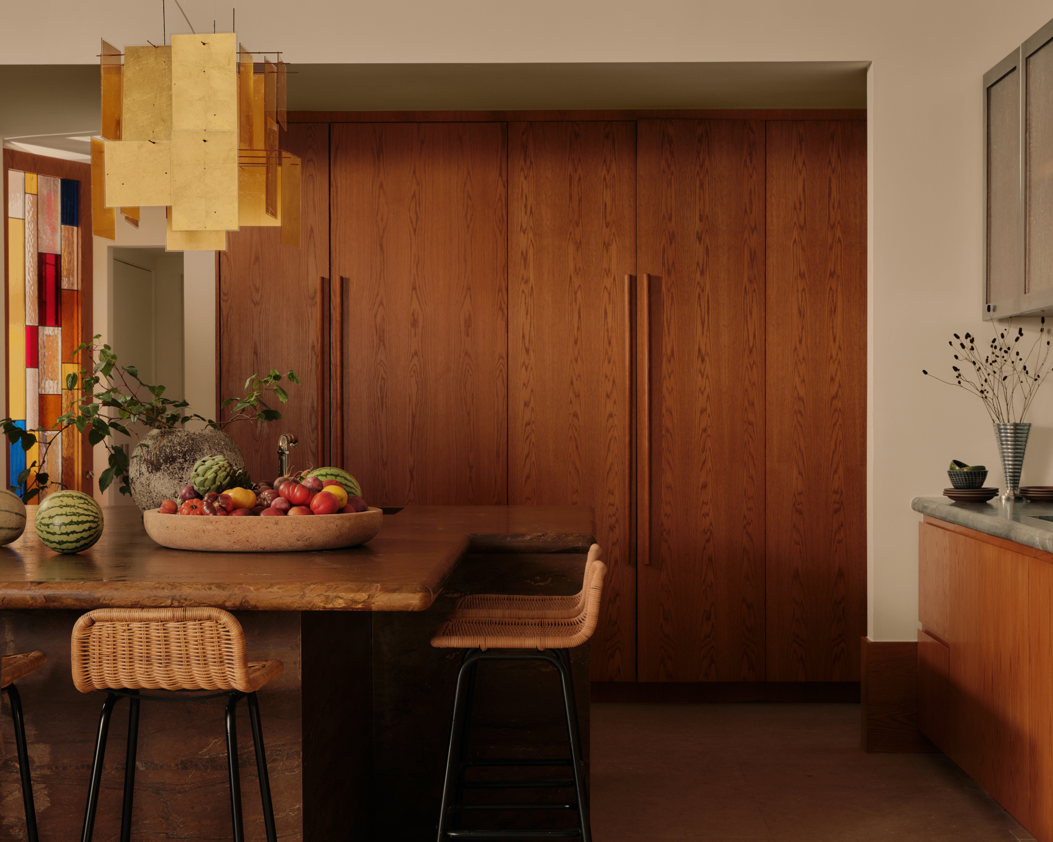 wooden paneled kitchen with an island filled with fruit