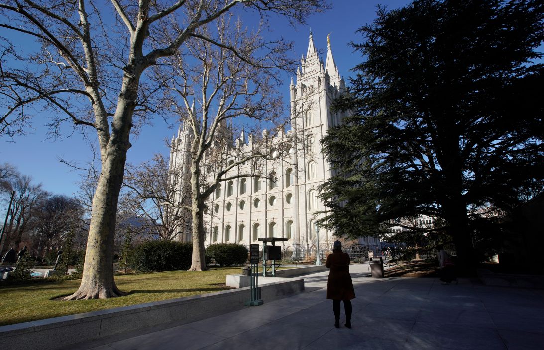 A woman takes a picture of The Church of Jesus Christ of Latter-Day Saints, historic Mormon Salt Lake Temple.