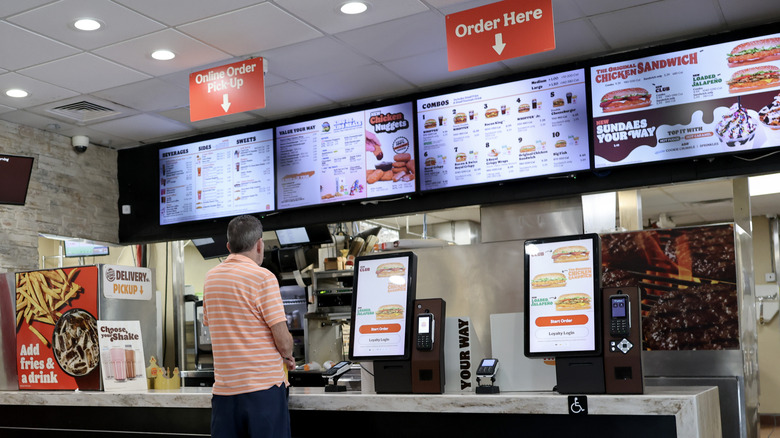 A man standing at a counter in a Burger King