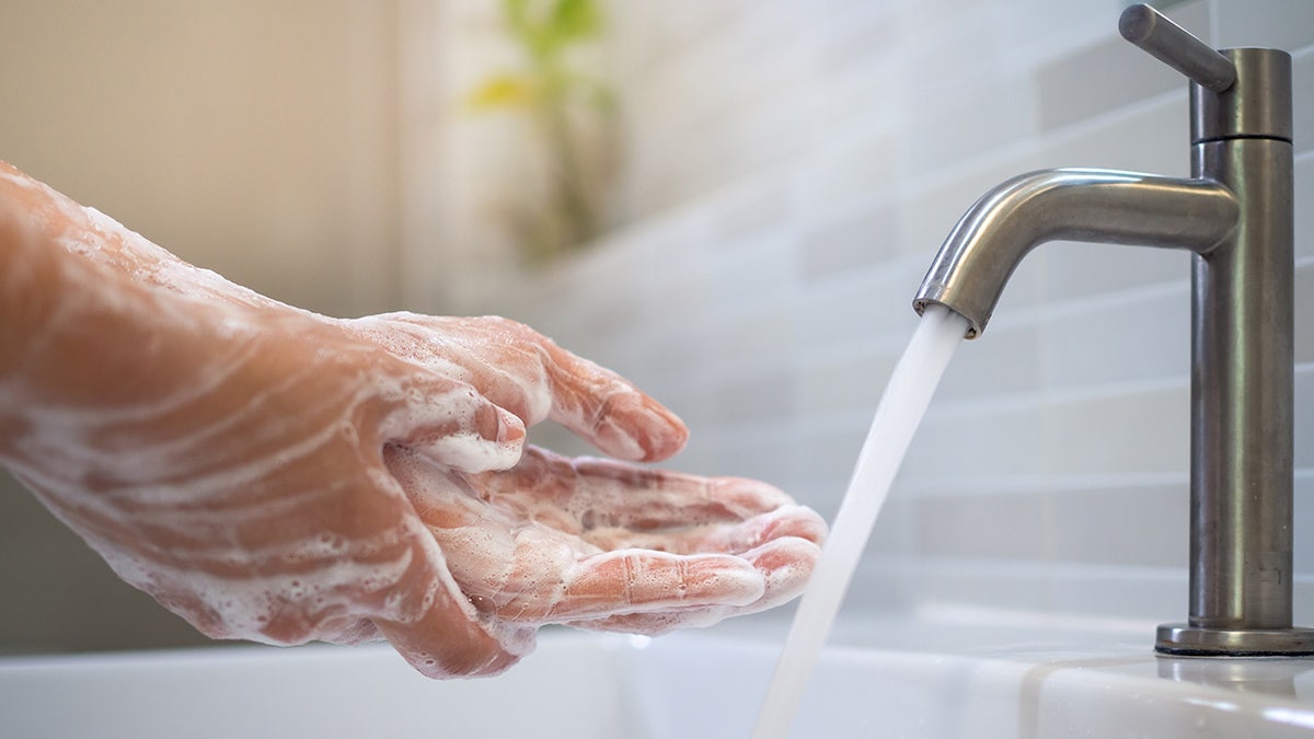Close up of women scrub hand soap with wash basin