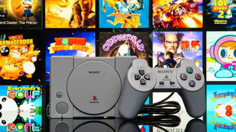 Sony PlayStation with a controller in front of a collage of retro titles