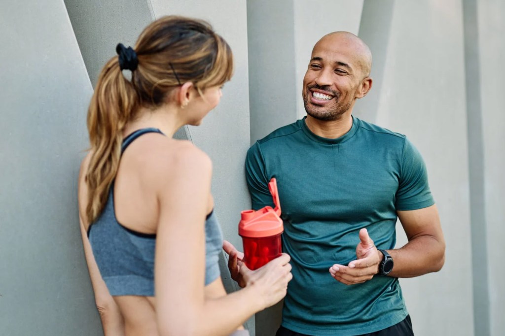 man and women talking in workout clothing