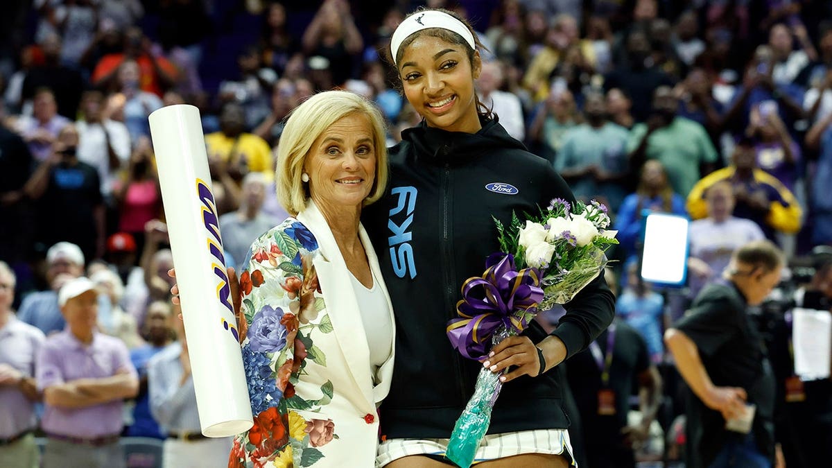 Kim Mulkey and Angel Reese pose together before a preseason game.