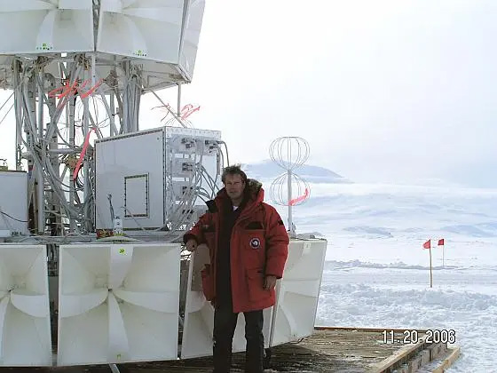 man in red coat on a ship in a sea of ice