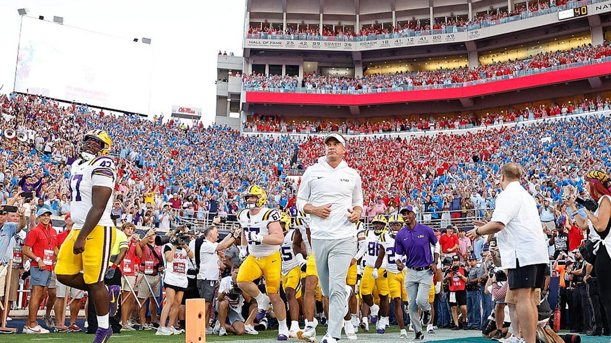 Lane Kiffin enters the field before a game at Vaught-Hemingway Stadium.