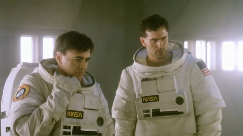 Walter Koenig as Colonel Jason Grant standing next to Bruce Campbell as Ray Tanner as they look at something off screen in Moontrap