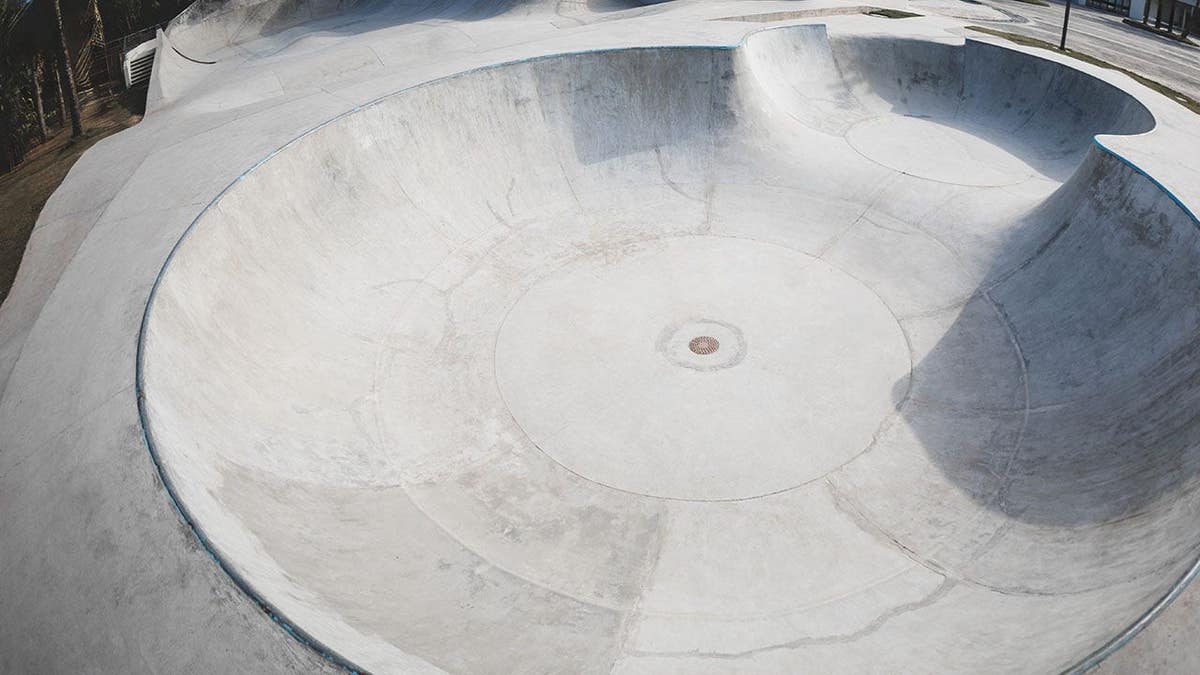 A concrete skatepark sits in a city.